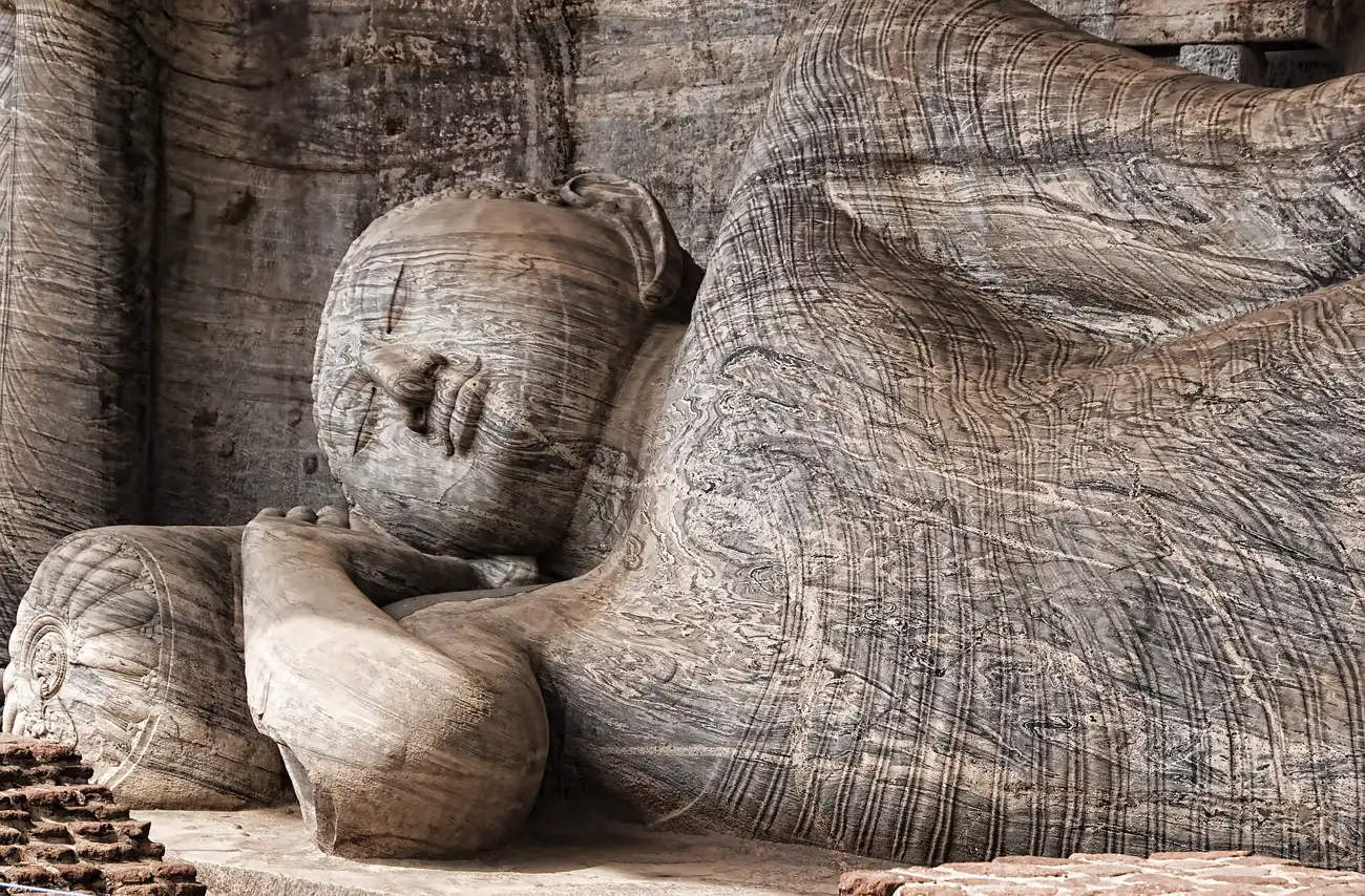 A colossal reclining Buddha carved into the granite rock face at Gal Vihara in Polonnaruwa.